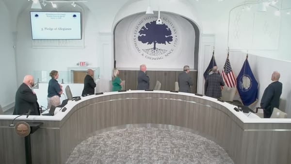 The Elizabethtown City Council standing at the dais during the Pledge of Allegiance at the August 3, 2026 regular meeting